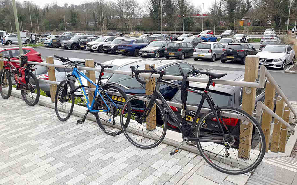 Several bicycles lean against a railing, secured with locks.